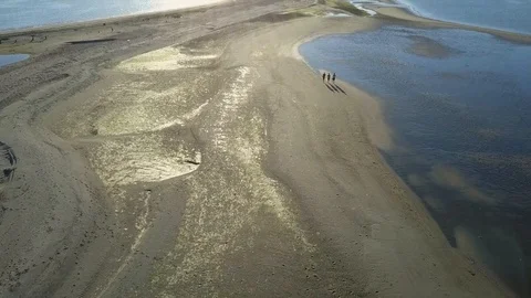 Drone shot of men walking on the beach at sunset, Vancouver Island BC 動画素材 86985750