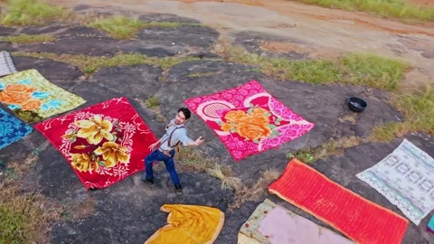 Drone shot model poses onto stony land surround by cloth Stock Footage 304848881