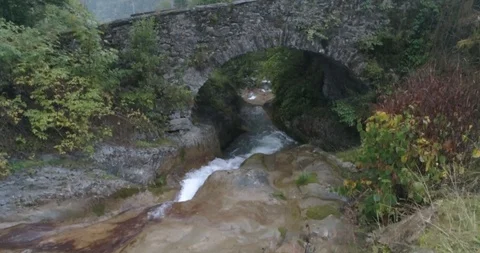 Drone Shot of montain river going under a stone bridge Stock-Footage 119204708