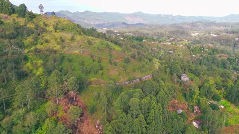 Drone Shot of Mountain Train Heading Toward Small Town Landscape Stock Footage 321606902