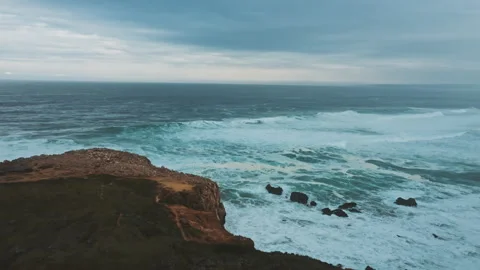 Drone shot in movement including men standing next to van and wild ocean coast Stock Footage 203597770