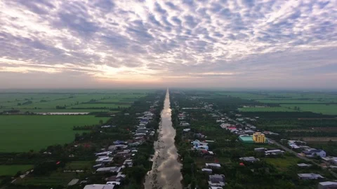 Drone shot moving forward over long village canal during peaceful sunrise Stock-Footage 342924375