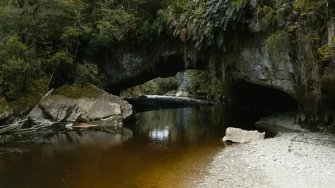 Drone shot of natural cavern with river running through in New Zealand Stock Footage 89998151