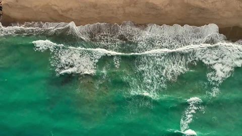 Drone shot no camera movement top down view of tropical waves on a beach Stock Footage 236742137