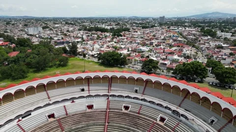 Drone shot of Nuevo Progreso Bullring, Guadalajara, Mexico, with city landscape Stock Footage 328524356