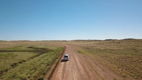 Drone shot orbiting around a white van driving on a asutralian red dirt road thr Stock Footage 294651928