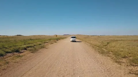 Drone shot orbiting around a white van driving on a asutralian red dirt road thr Video stock 294652001