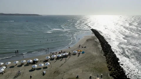 Drone shot over the a beach, toward parasailers on the coast of Cartagena, Stock Footage 237421042
