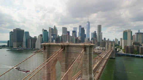 Drone shot over Brooklyn Bridge with American flag and East River view over Stock Footage 208896601