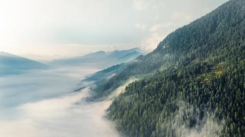 Drone shot over epic mountains above a cloud wall Stock Photos