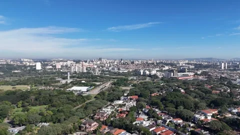 Drone shot over a lush green area surrounded by trees and nature near Vídeo Stock 341663753
