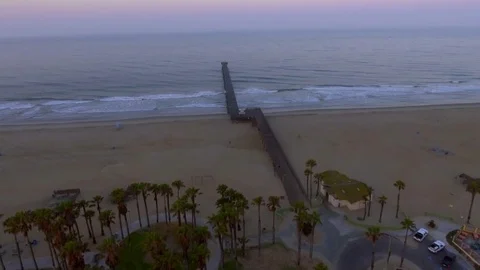 Drone shot over the ocean shoreline flying over the pier on sunrise Rec709 Stock Footage 82744542