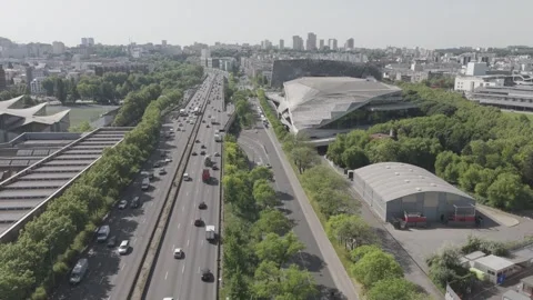 Drone Shot Over Paris Ring Road with Buildings, Greenery, and Distant Stock Footage 309265347