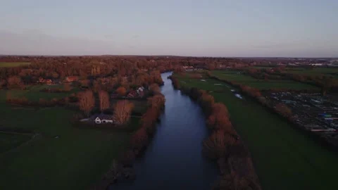 Drone shot over river and trees, green fields and houses during autumn winter Stock Footage 167769248