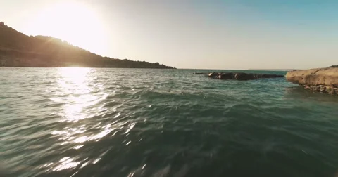 Drone shot over the sea moving towards the sun Stock Footage 67157755