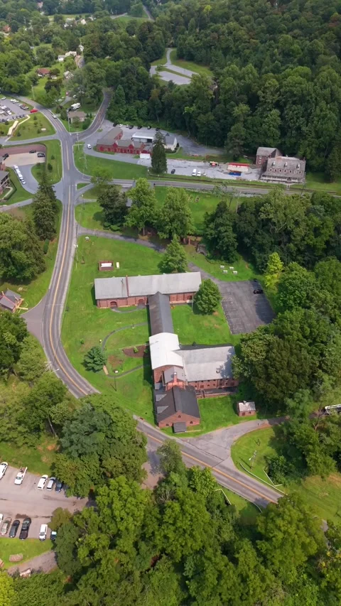 Drone shot panning over the historic stone furnace buildings, parking area, and Vídeos de archivo 342834165