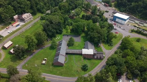 Drone shot panning over the historic stone furnace buildings, parking area, and Vídeos de archivo 342834185
