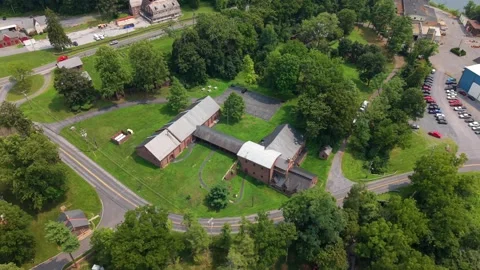 Drone shot panning over the historic stone furnace buildings, parking area, and Vídeos de archivo 342834292