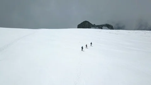 Drone shot of people in glacier snow mountain climbing ice Stock Footage