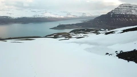 Drone Shot of people skiing and snowboarding on a snowy mountain in Eastfjords Video stock 118320331