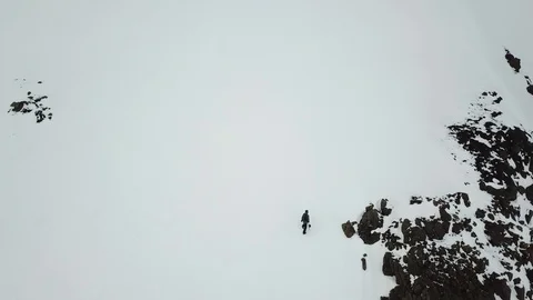 Drone Shot of people skiing and snowboarding on a snowy mountain in Eastfjords Stock Footage 118322012