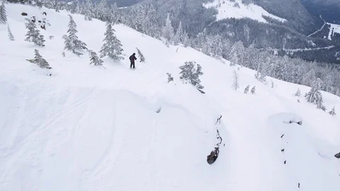 Drone shot of pro skier skiing down on snowy hill on cloudy day, Red Mountain Stock Footage 121585537