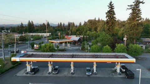 Drone shot pulling away from cars filling up at a gas station. Stock Footage 247121674