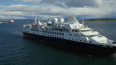 Drone Shot Pulling Away from a Small Cruise Ship in Puerto Natales Stock Footage 100682506