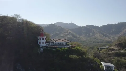 Drone shot pulling back on a mountain side lighthouse Stock Footage 103344747
