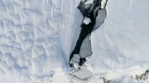 Drone Shot Pulling Back From Snowy Waterfall in Iceland in 4K Stock Footage 89439999