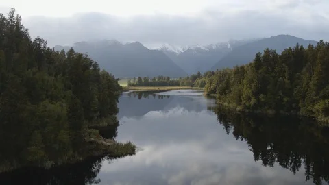 Drone shot pulling out from a clear reflective lake in New Zealand Stock Footage 86501887