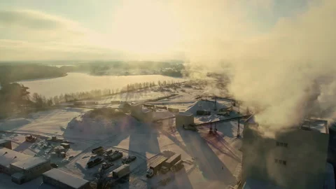 Drone shot of a pulp mill pumping out steam with snow covering the ground. Stock Footage 260305761