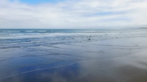 Drone shot push-in group of surfers in cold New Zealand water Stock Footage 89891922