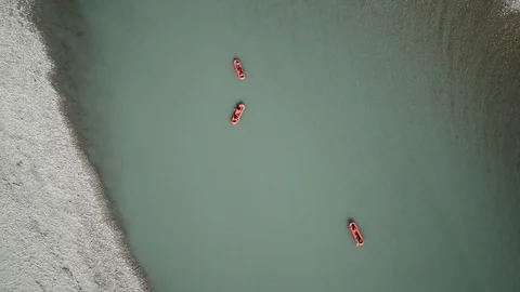 Drone shot of red boats rowing down an alpine rocky river in New Zealand Stock Footage 86496496