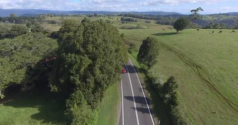 Drone shot of red car driving in the countryside of Australia kangaroo road s Stock Footage 80963456