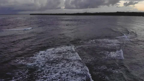 Drone shot of reef beach with waves at twilight with clouds 库存影片 130843439