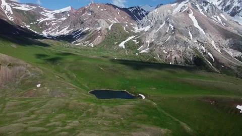Drone shot of remote glacial pond under massive mountain walls in Kazakhstan 库存影片 337207172