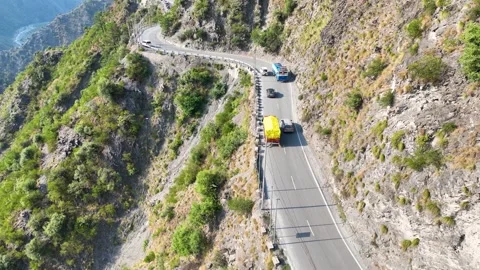 Drone shot of remote logistics trucks driving on winding highway pass. Stock-Footage 337615469