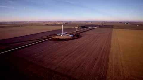 Drone shot revolving around wind turbines in early build phase Video stock 329222220