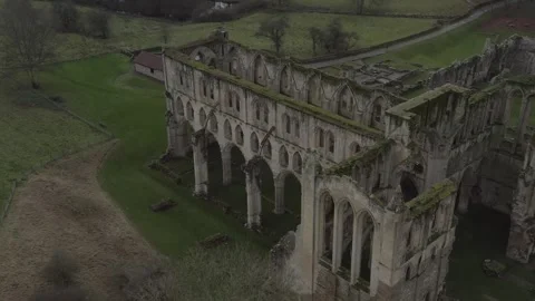 Drone shot of Rievaulx Abbey, showcasing the historical ruins surrounded by 스톡 동영상 296760733