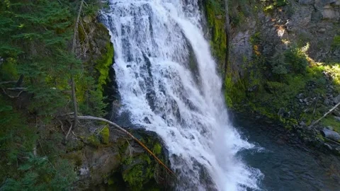 Drone shot rises up a flowing waterfall in the woods Stock Footage 318476970