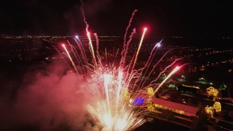 Drone shot rising over a vibrant fireworks display during a nighttime Stock Footage 334675581