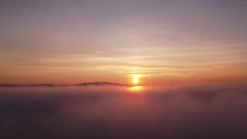 Drone shot rising through the clouds to reveal a sunset Video stock 233221060