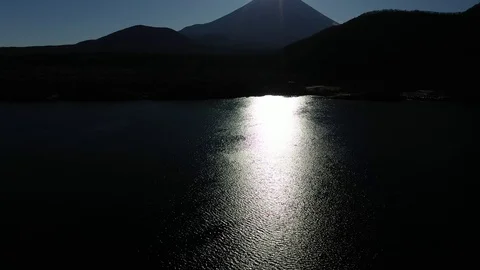 Drone shot of river surface reflecting sun shine and Fuji mountain in Japan Stock Footage 122572467