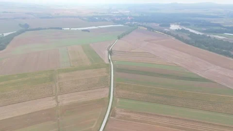 Drone shot of a road cutting through fields under rainy skies. The road lea.. Stock Footage 284871804