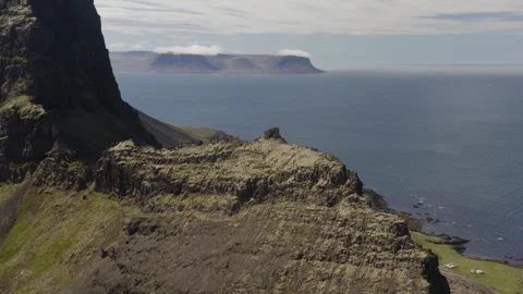 Drone shot rotating around a lower peak on a steak rocky mountain cliff on Stock-Footage 255014538