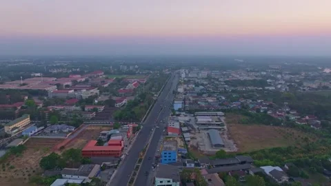 Drone shot of Sam Phran city glowing under the warm sunset sky, Thailand Stock Footage 304374248