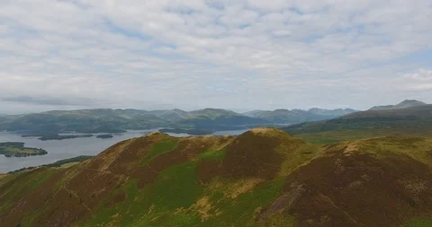 Drone Shot of Scottish Landscape Featuring Green Hills and Clouds 스톡 동영상 97572107