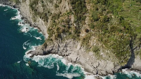 Drone shot of sea waves crashing on the rocks in sunny day Stock Footage