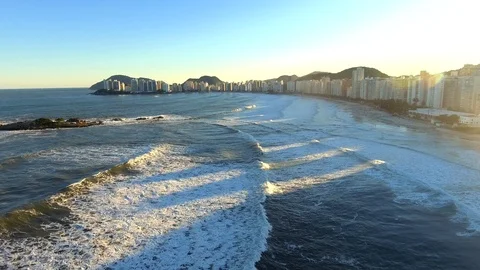 Drone shot of sea waves reaching Pitangueiras beach with city skyline Vídeo Stock 114845852